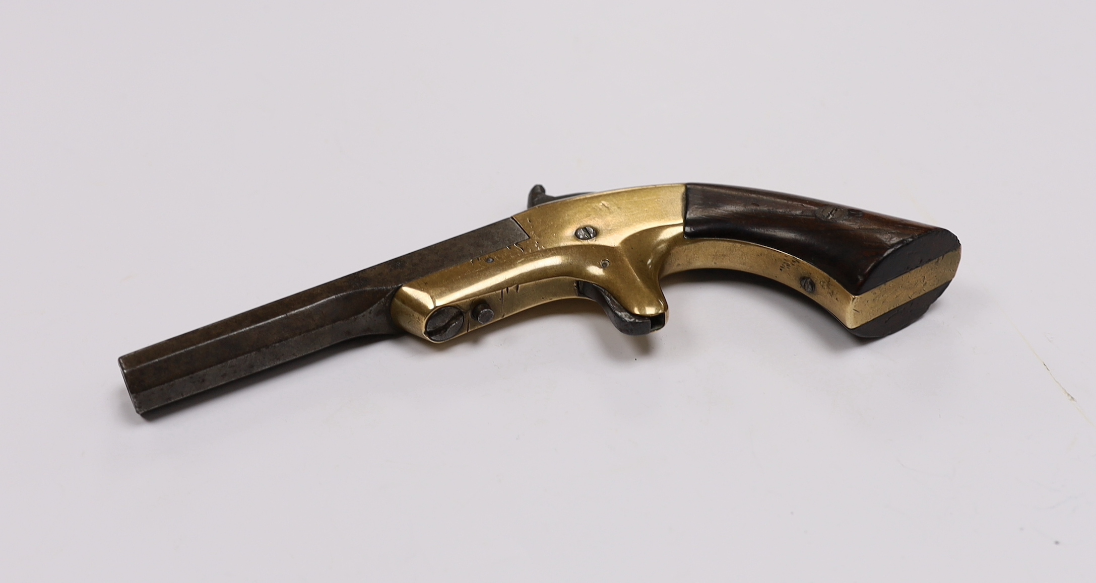 A 19th century miniature percussion pistol with brass lock and octagonal barrel, stamped Morgan and Clapp Newhaven CT, barrel 9cm